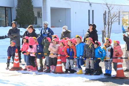 雪上で消防訓練を見学する園児たちの写真