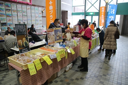 文化祭会場のロビーで行われた物販会場で買い物をする人、販売する人の写真