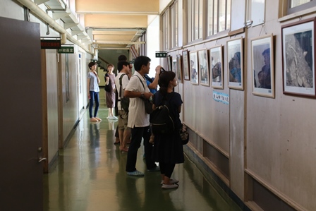 校舎の廊下に額に入れられた写真が並べて掲示されている写真