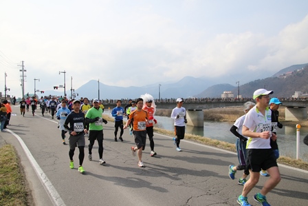 川沿いの道を走るランナーたちの写真