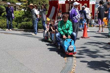 機関車トーマスのキャラクターの乗り物に乗る来場者たちの写真