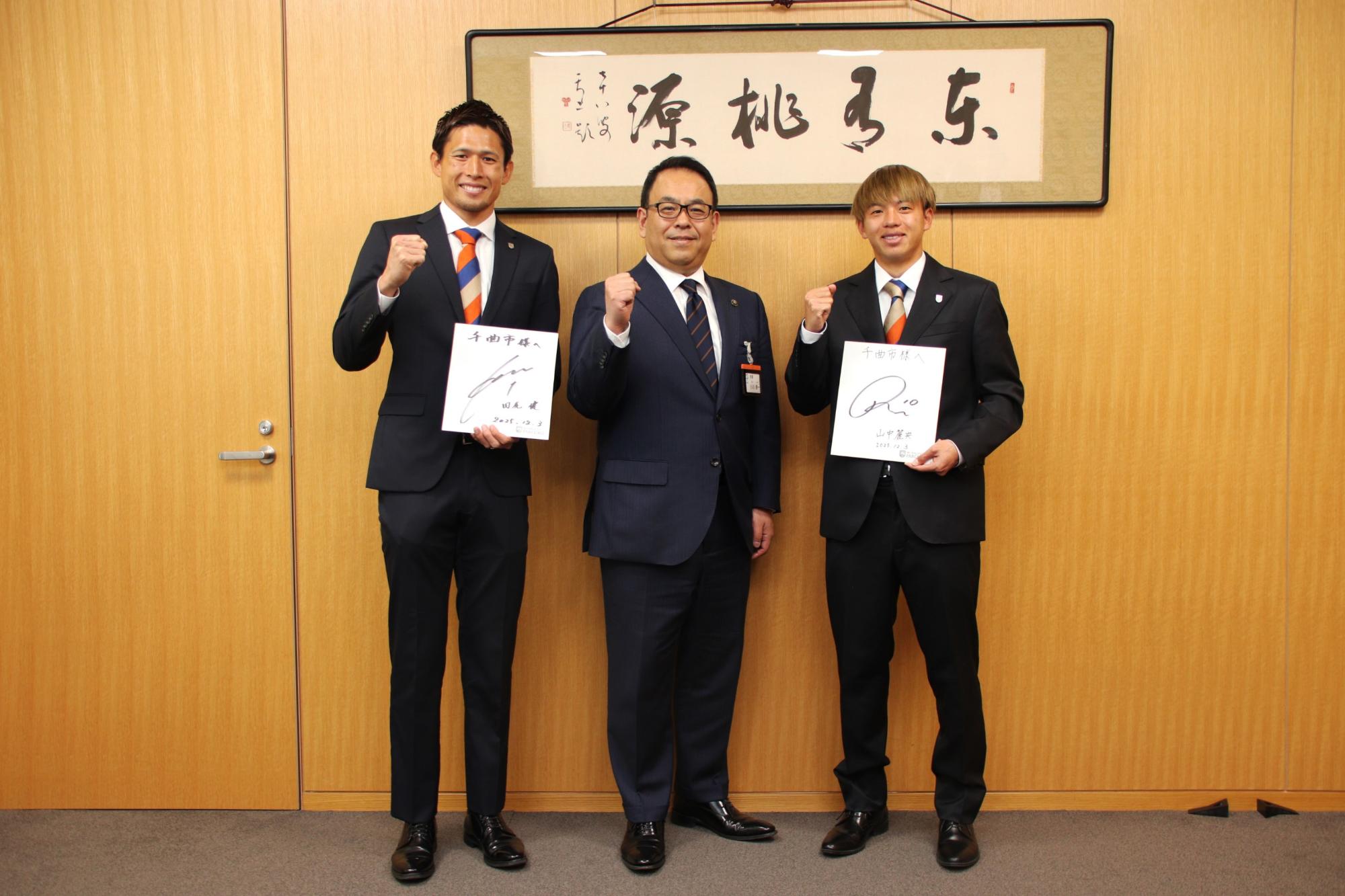 記念写真（左からAC長野パルセイロホームタウンパートナープレーヤー田尻健選手、小川修一市長、AC長野パルセイロホームタウンパートナープレーヤー山中麗央選手）