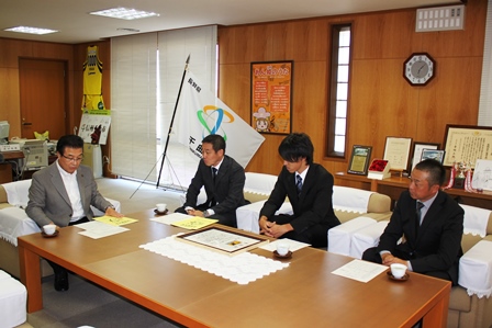 市長とともに机に並び話を聞いている3人のスーツ姿の男性の写真