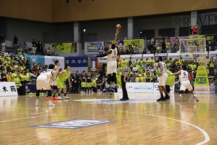 高くジャンプしてパスしたボールを受け取っているバスケットボール選手と試合の写真