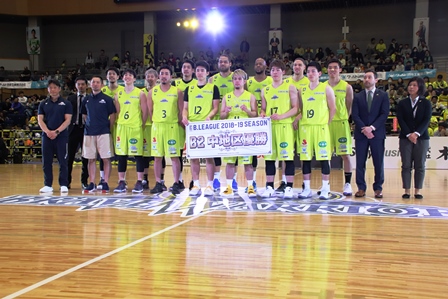 黄色いユニフォームのバスケットボールチームが地区で優勝した時の写真