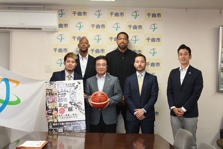 バスケットボールを持った市長とポスターを持った男性と他4名の男性の写真