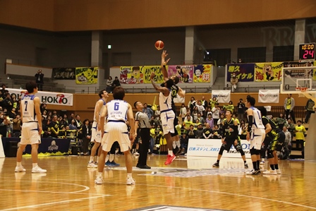 バスケットボールの試合で高くジャンプしてボールを奪い合う選手二人の写真
