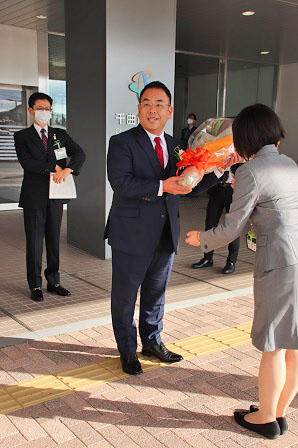 屋外で花束を受け取る小川市長の写真