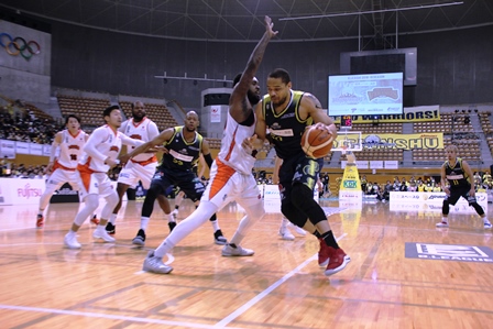 バスケットボールの試合でドリブルしている選手と立ちはだかる敵チームの写真