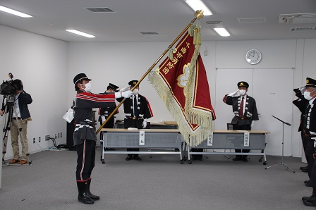 大きな旗を持った男性隊員が背筋を伸ばして立っている写真