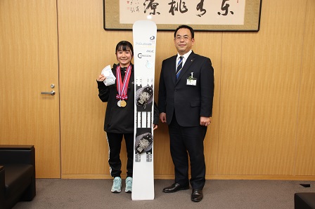 市長とメダルを首からかけた宮尾さんが記念撮影をしている写真