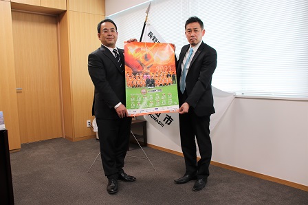 ポスターを広げている市長と監督の写真