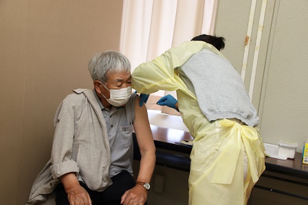 マスクをつけた男性と、予防接種をする看護師の写真