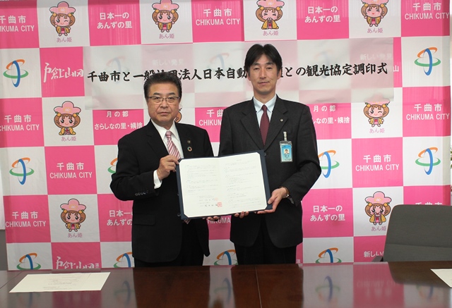 協定書を手にカメラのほうを向く市長と福田所長の写真