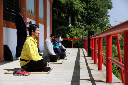 寺院で静かに座禅を組んでいる参加者たちの写真