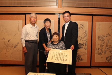 今年度で100歳を迎える春日都さんとその家族と市長との記念写真