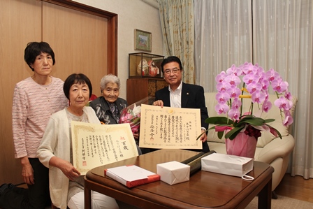 今年度で100歳を迎える木下けさゑさんとその家族と市長との記念写真