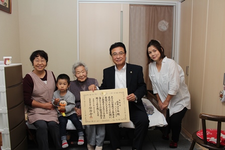 今年度で100歳を迎える西澤けさみさんとその家族と市長との記念写真
