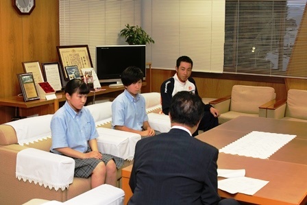 応接室で市長が永野商業高等学校ソフトボール部の生徒2人と上田西高等学校軟式野球部の生徒に激励している写真