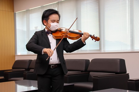 タキシードに身を包んだ小出くんがヴァイオリン演奏を披露している写真