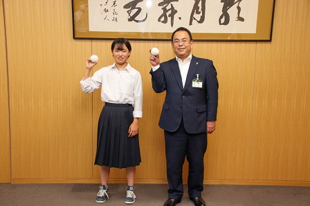 野球ボールを手に持ち記念撮影をしている市長と堀口さんの写真
