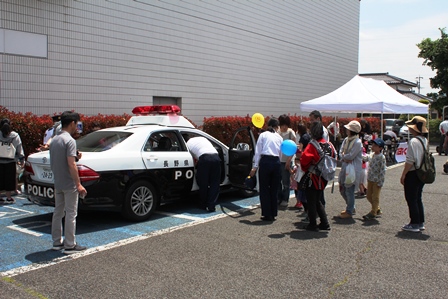 パトカーの乗車体験ブースに老若男女が並んでいる写真