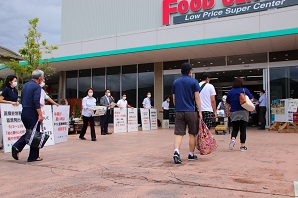 スーパーマーケットの入口でお客さんが入ってきているすぐ隣で啓発運動を行っている写真