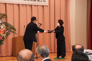 小川市長が園名採用代表者の町田美千代さんへ感謝状を手渡す様子