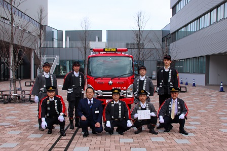 配置された車両と記念撮影する市消防団第7分団の団員、小川市長、武井消防団長