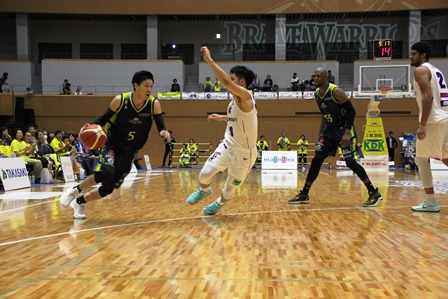 バスケットボールの試合で二人の選手が攻防戦の最中の写真