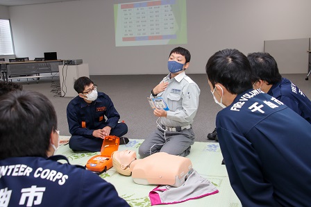 AEDと模型を使って使用方法を説明する講師の写真