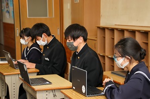 学生たちがパソコンのモニターを見つめている写真