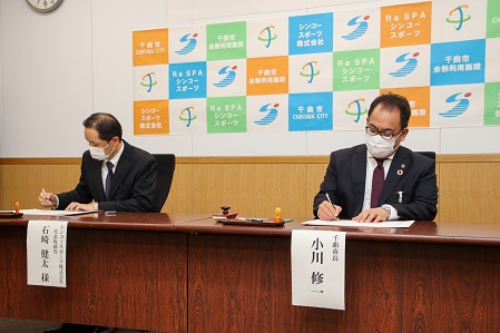 協定書に署名するシンコースポーツ株式会社の石崎代表取締役と小川市長