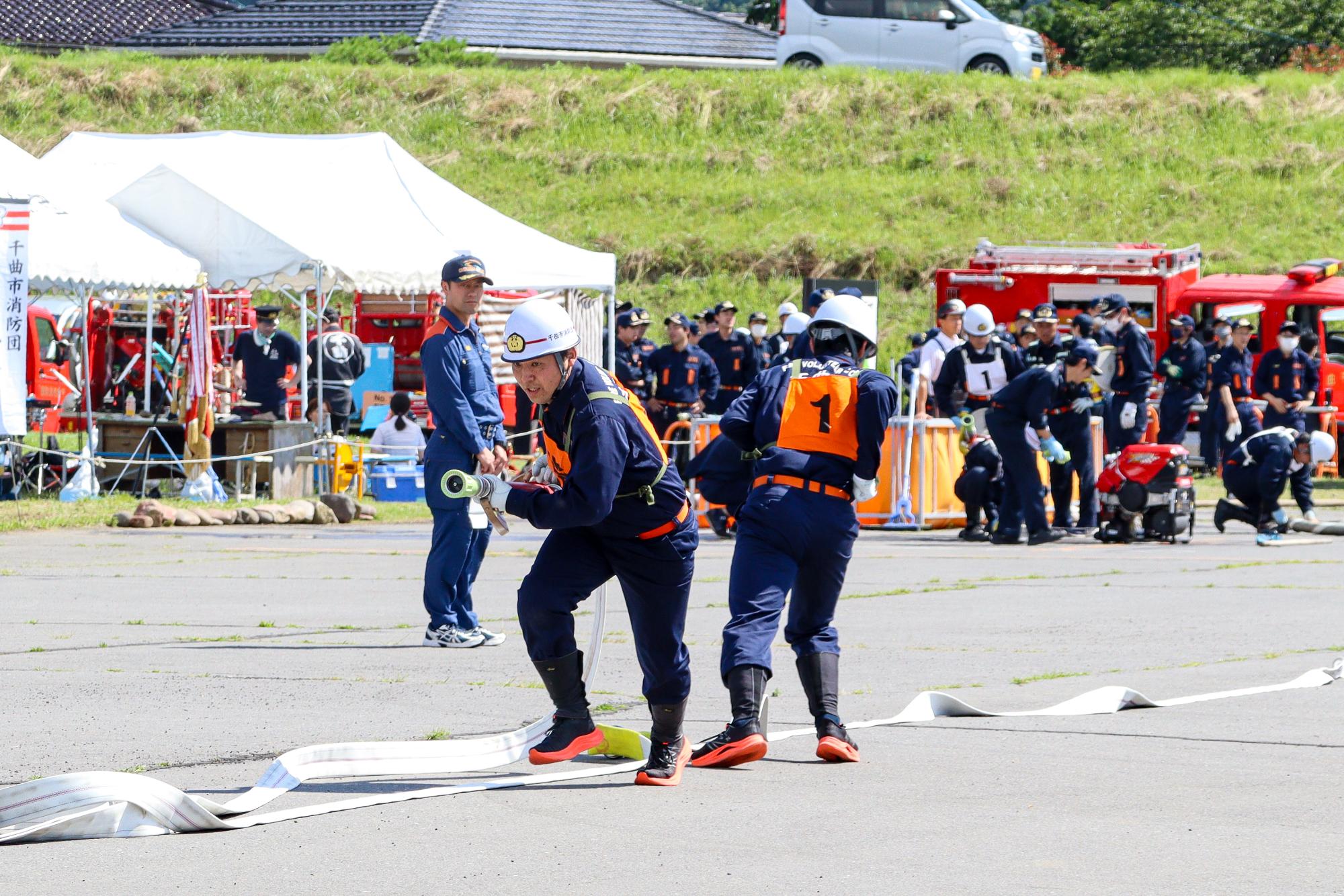 小型ポンプ操法で優勝した第1分団の指揮者と一番員が分かれて走るシーン