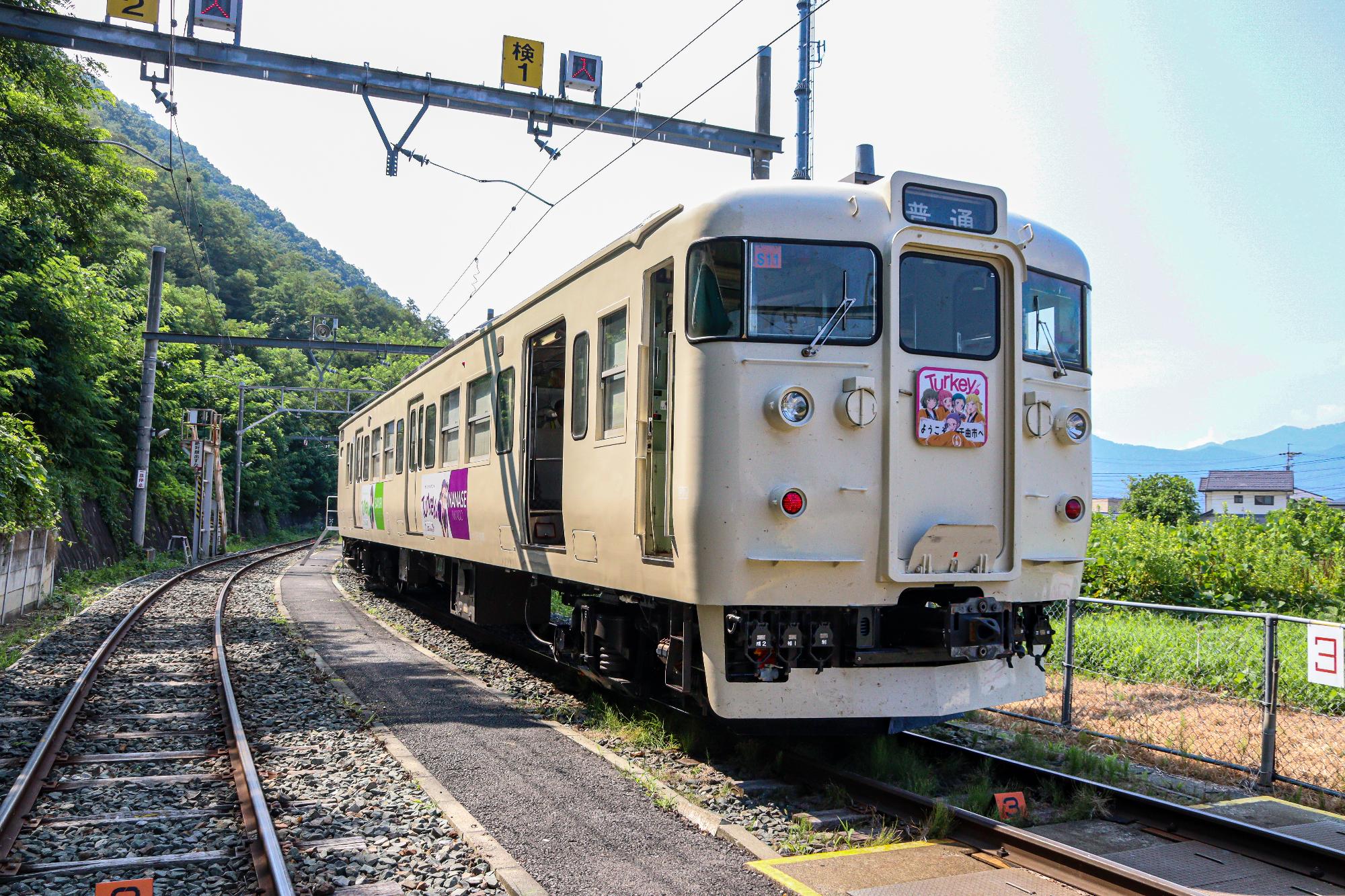 ラッピングされた115系列車を左前方から撮影