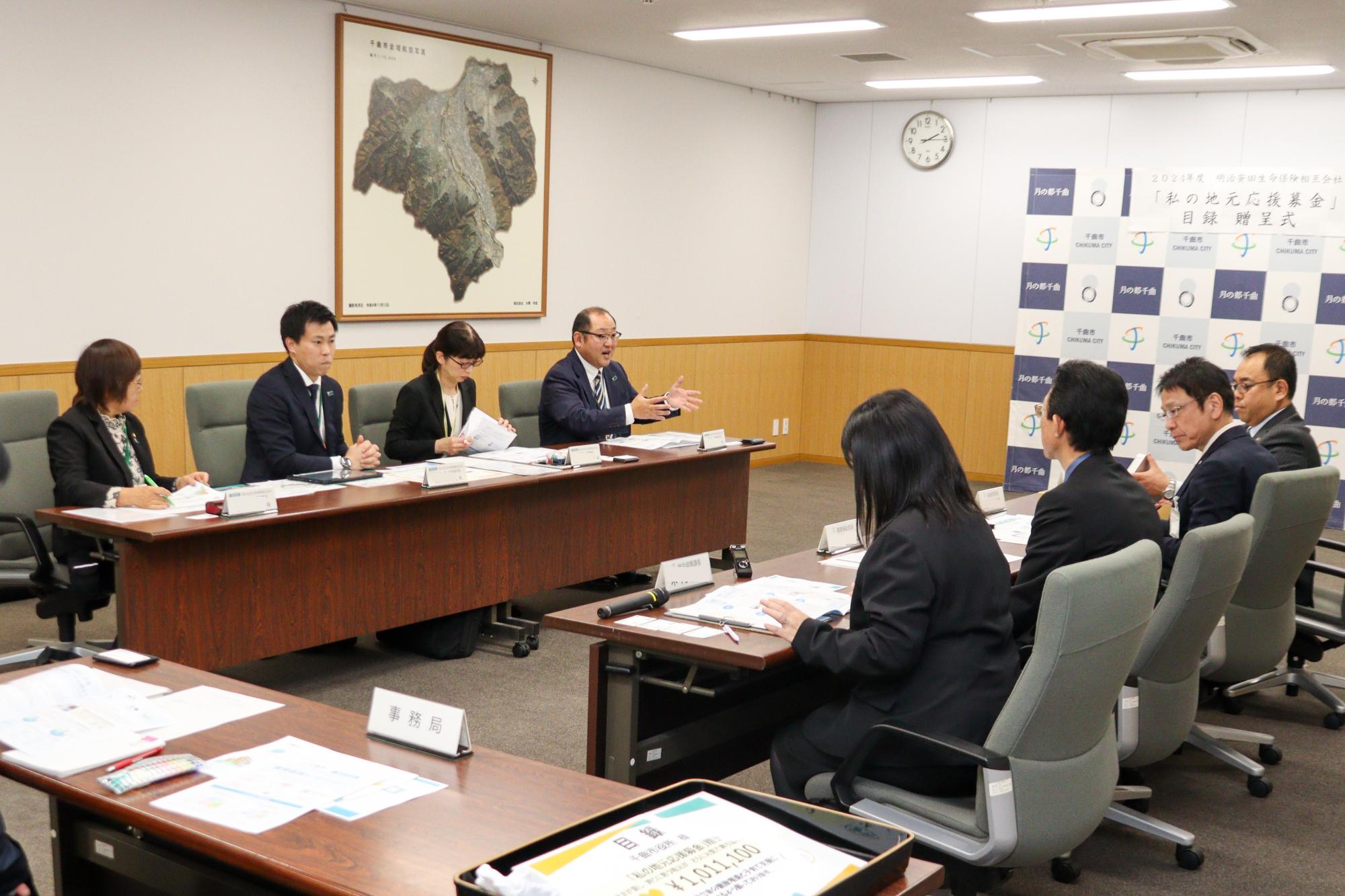 明治安田生命の担当者4人と市の担当者4人が懇談する様子