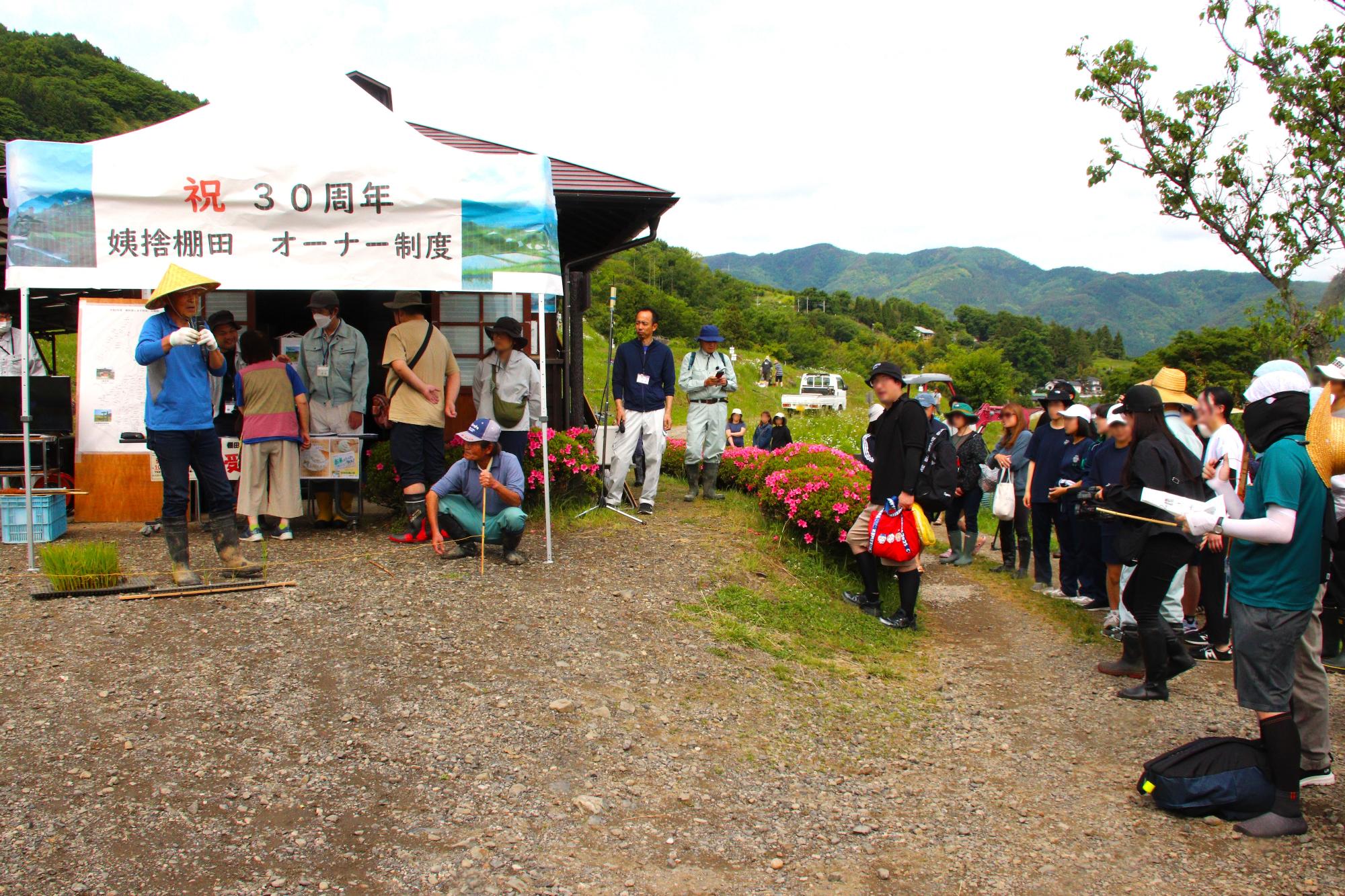 田植えの方法を参加者に教えている様子