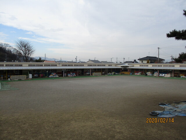 広い砂地の園庭とそれに面する稲荷山保育園の写真