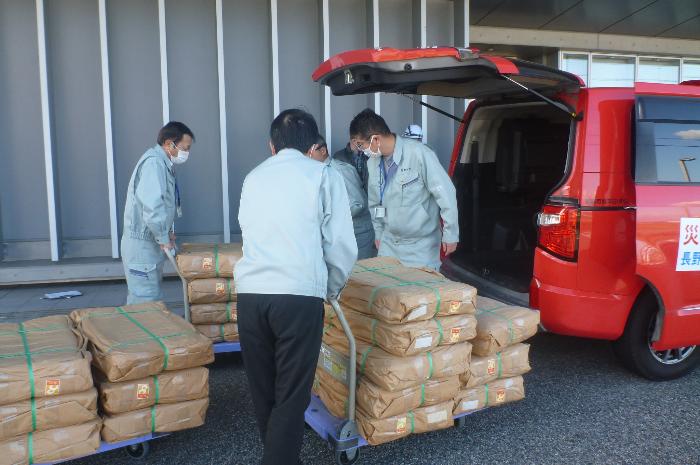 千曲市役所職員が射水市役所職員に支援物資を渡す写真